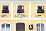 Fassade der Hoftaverne Ziegelböck in Vorchdorf mit gelber Außenwand, Blumenschmuck und traditioneller Beschriftung