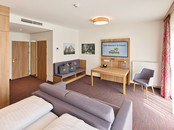 Wohnbereich der Junior Suite mit Sofa und Fernseher