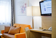 Wohnbereich im Komfort-Zimmer mit Sofa und TV