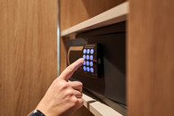 Gast bedient Hotelsafe im Komfortzimmer S der Hoftaverne Ziegelböck