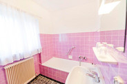 Badezimmer im Simple-Zimmer der Hoftaverne Ziegelböck mit rosa Fliesen und Badewanne